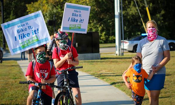 Students hold up Walk-to-School signs